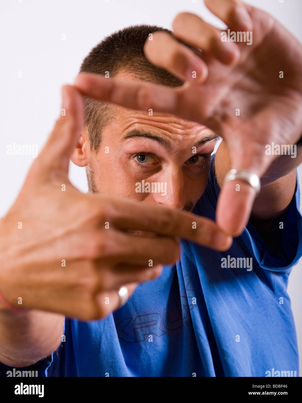 Porträt eines jungen Mannes mit Händen, seinem Gesicht einrahmen Stockfoto
