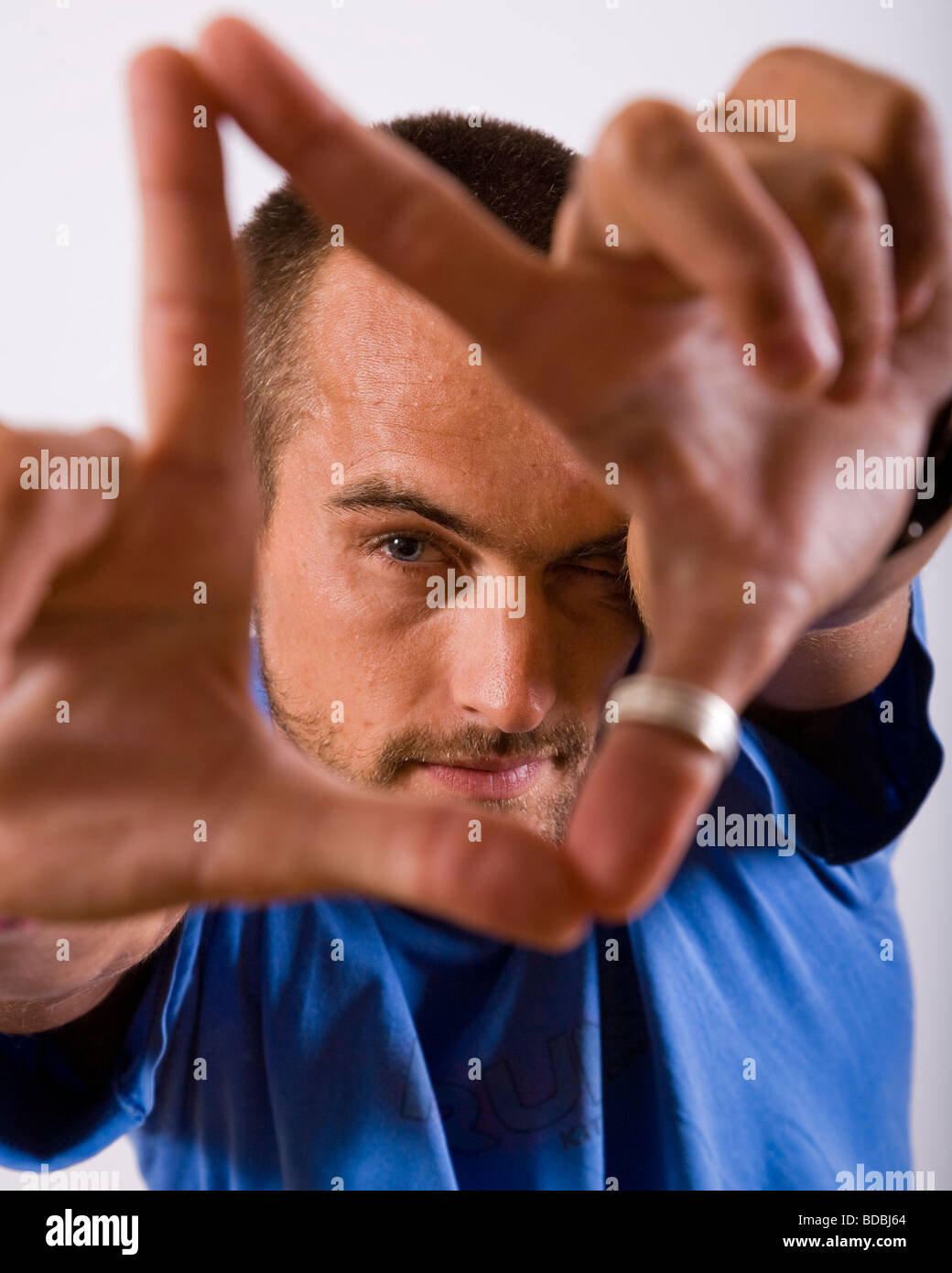 Porträt eines jungen Mannes mit Händen, seinem Gesicht einrahmen Stockfoto