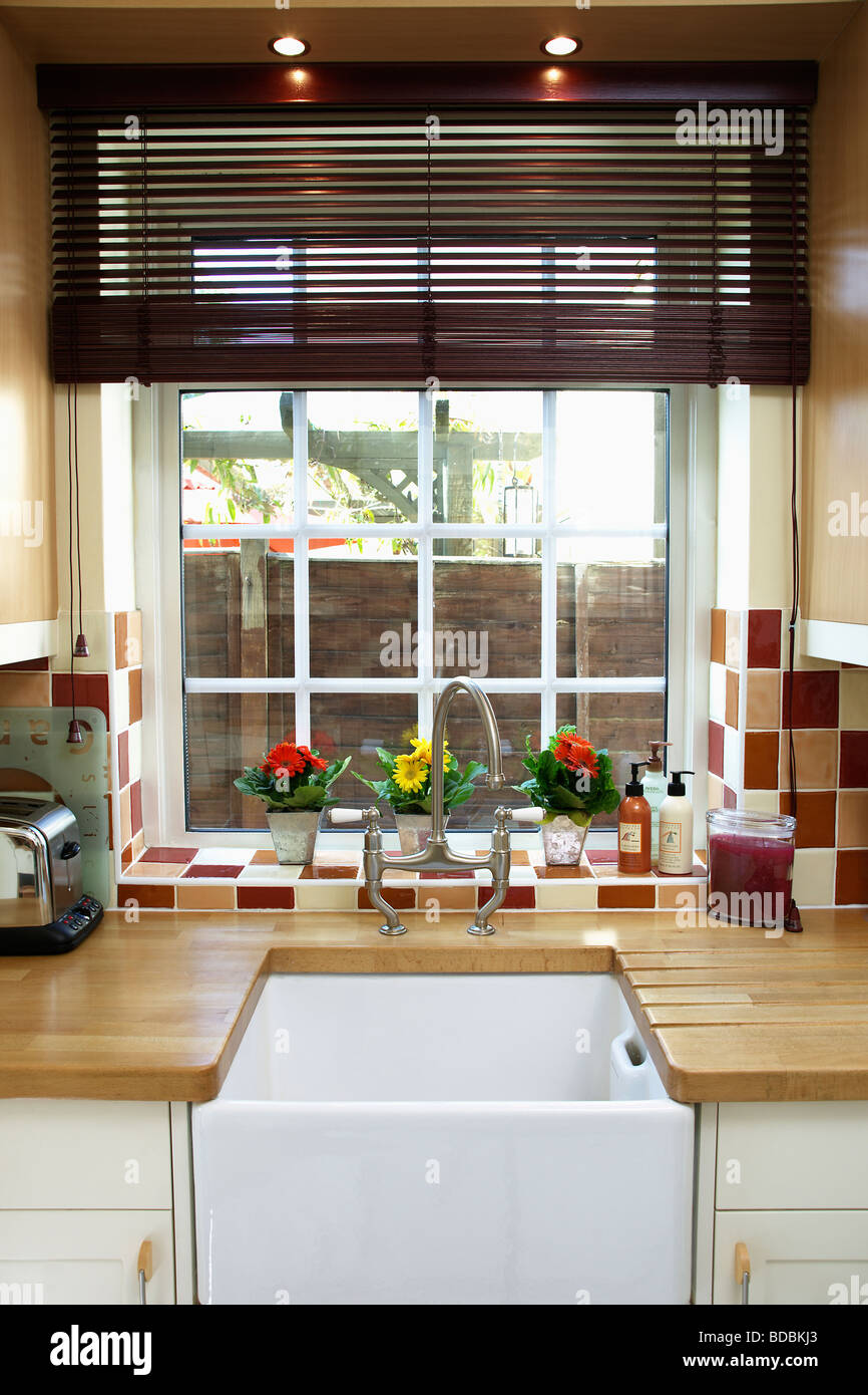 Lattenrost Blind auf Fenster über Belfast Spüle in der Küche mit Holz Arbeitsplatten Stockfoto