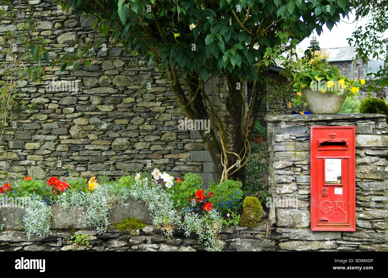 Roten Briefkasten montiert in eine Steinmauer Stockfoto