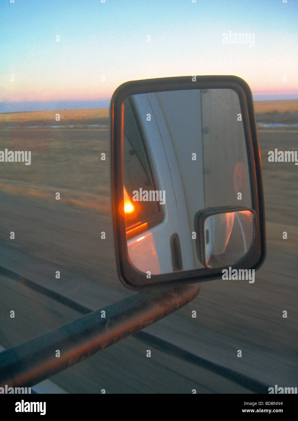 Sonnenuntergang in einem Außenspiegel eines LKW gesehen Stockfoto