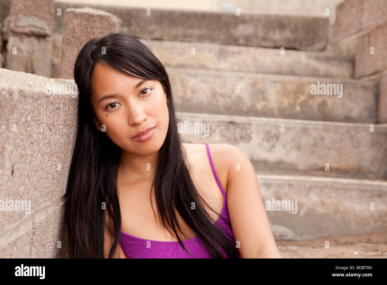 Porträt des philippinischen Frau trägt lila Bluse sitzt auf Beton Treppe/Schritt. Stockfoto