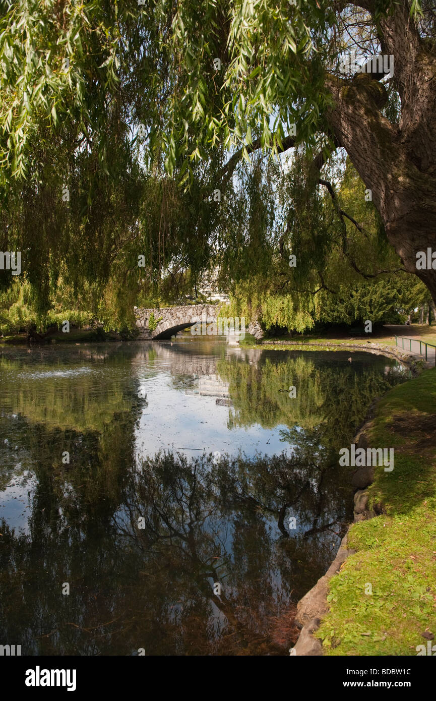 Ein schöner Tag in Beacon Hill Park, Victoria, Britisch-Kolumbien. Eine Bogenbrücke aus Stein und Teich bietet ein idyllischer Ort für das Mittagessen Stockfoto