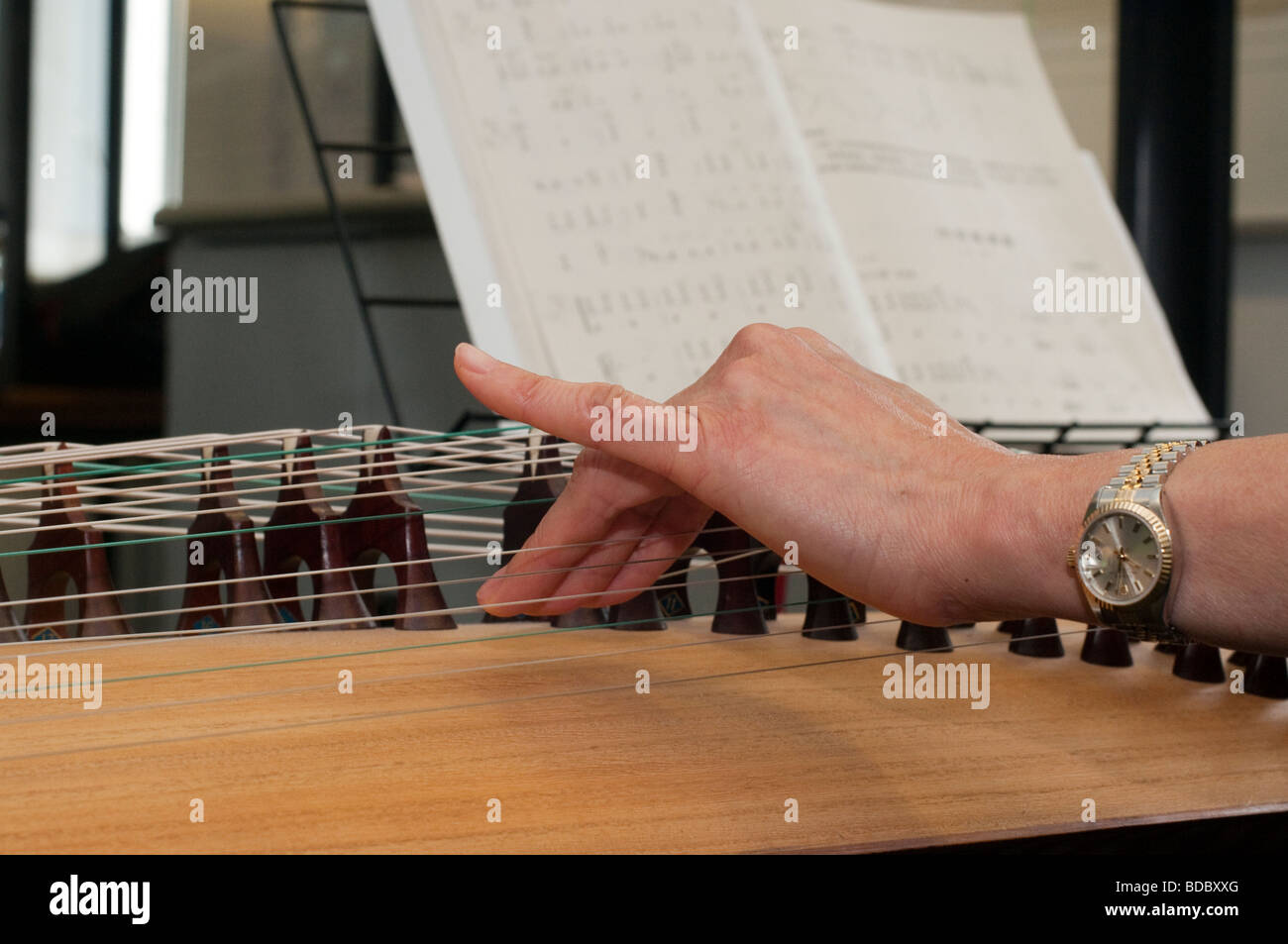 Detail von einem chinesischen Zheng aka Guzheng zeigt die Biegung der Zeichenfolge mit den Fingern um unterschiedliche Effekte zu erzielen Stockfoto