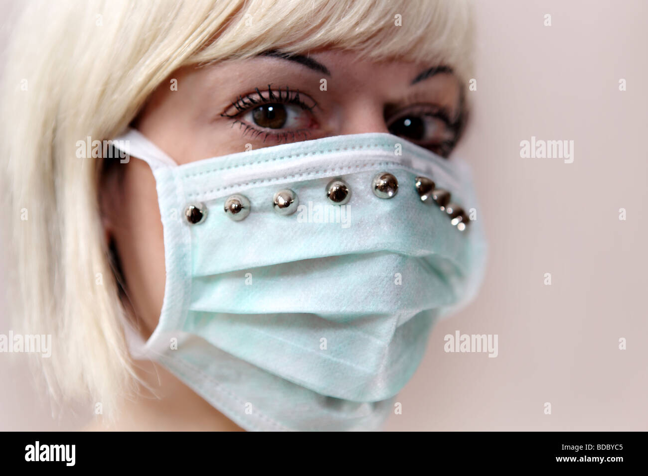 Ein blondes Mädchen tragen eine maßgeschneiderte chirurgische Gesichtsmaske. Stockfoto