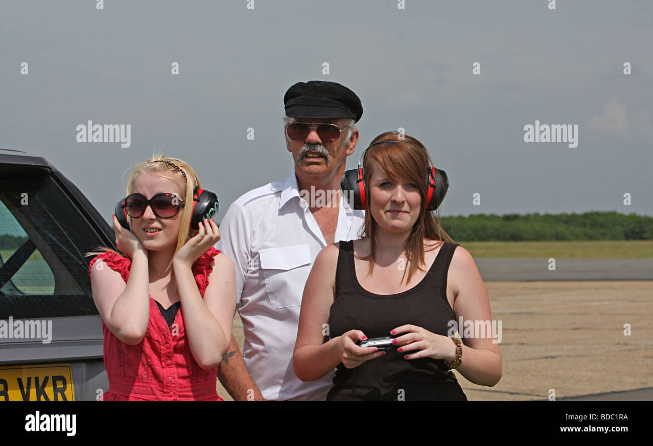 Drei Leute zu beobachten eine Flugschau Stockfoto