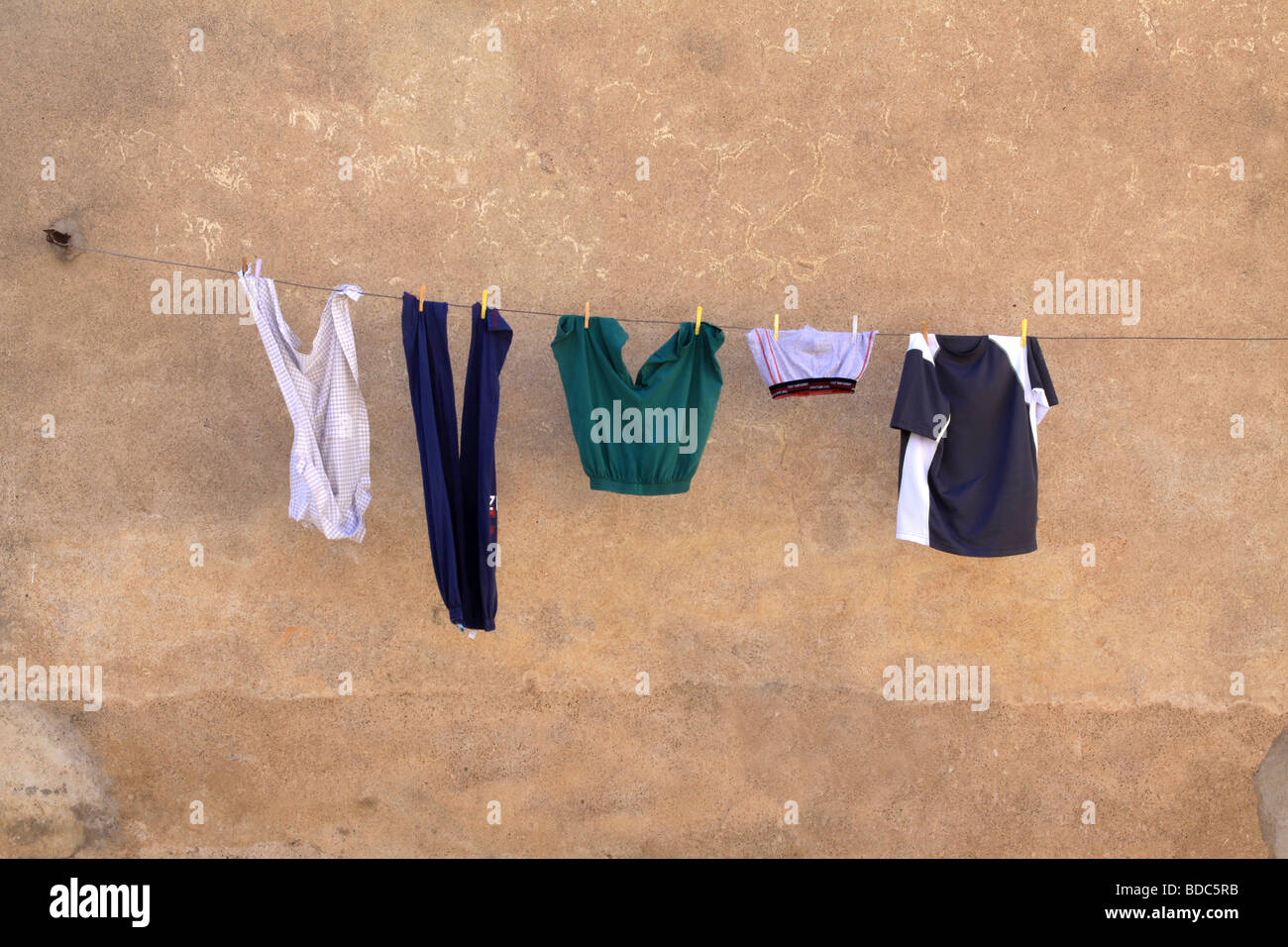 Städtische Szene der Waschmaschine hängen in der Straße zum Trocknen an einem warmen farbigen Wand Stockfoto