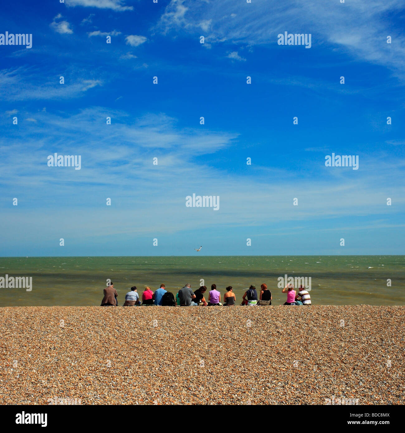 Gruppe von Menschen sitzen an einem Strand. Stockfoto