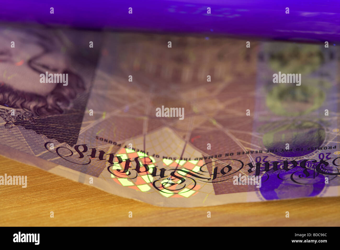 mit Hilfe eines UV schwarz-Lichts eine zwanzig Pfund Anmerkung Bank von England Banknoten zu überprüfen, ob es echt ist Stockfoto