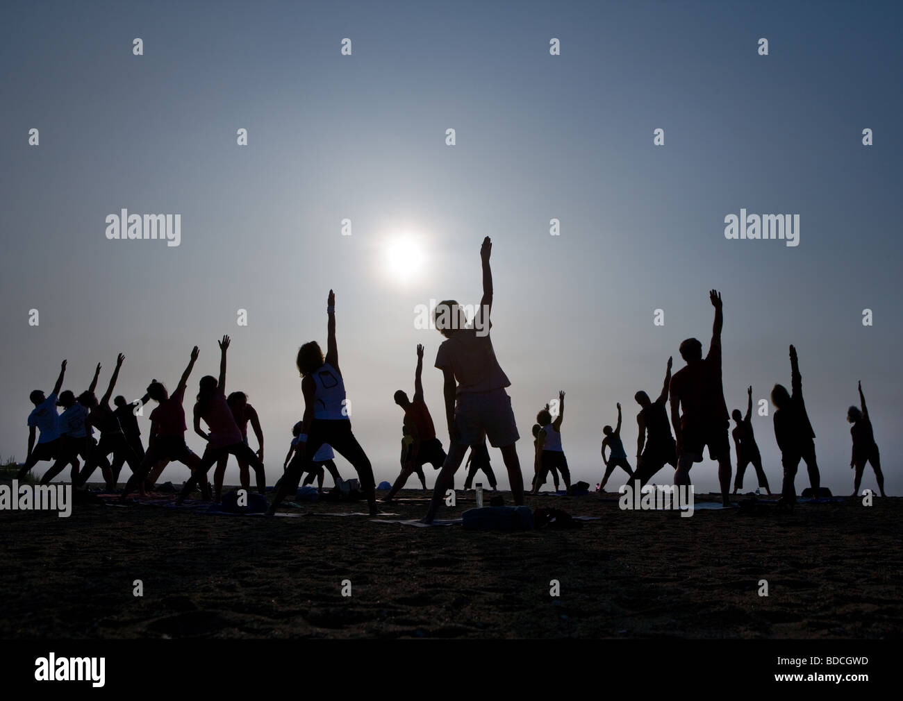 Ein Yoga-Kurs erstreckt sich in Richtung des Himmels an einem Strand in Guilford Connecticut USA Stockfoto