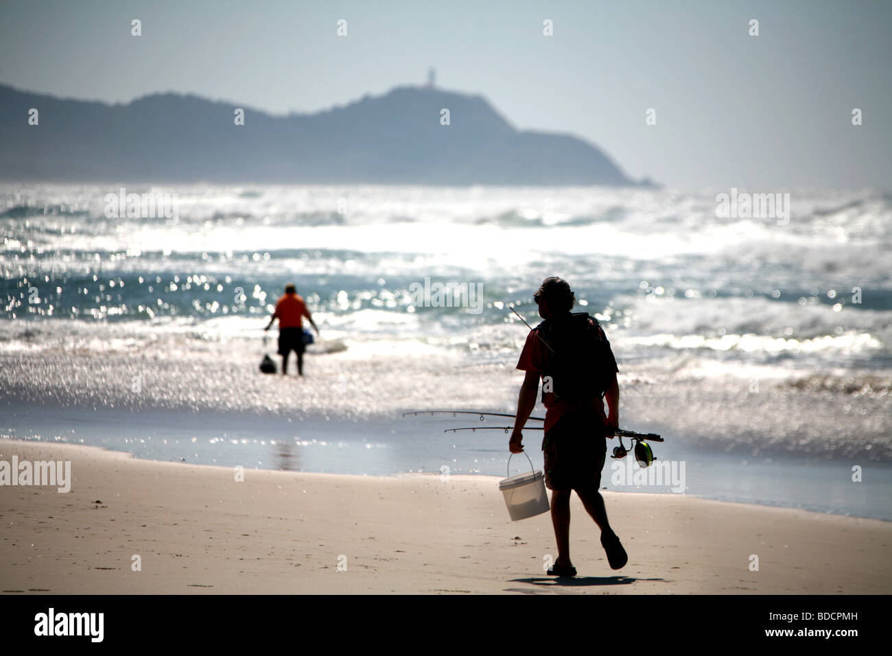 Ein Strand-Fischer Spaziergänge vorbei an einem Mann Strand Würmer im Talg Beach in der Nähe von Byron Bay Australien sammeln. Stockfoto