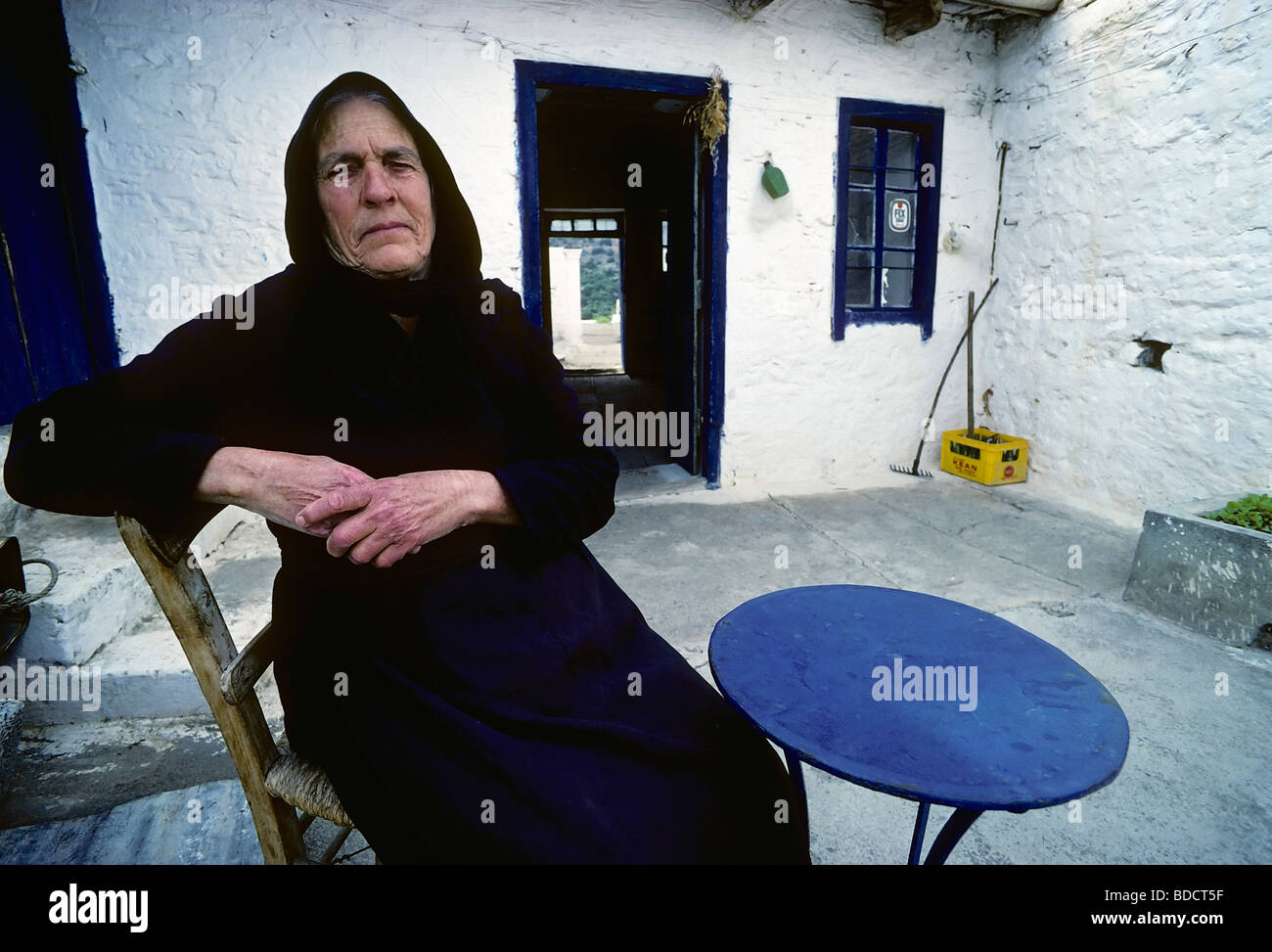 Alte Griechin in schwarz gekleidet, Bäuerin mit abgenutzten Händen, sitzen im Hof ihres Hauses, Porträt, Elounta, Stockfoto