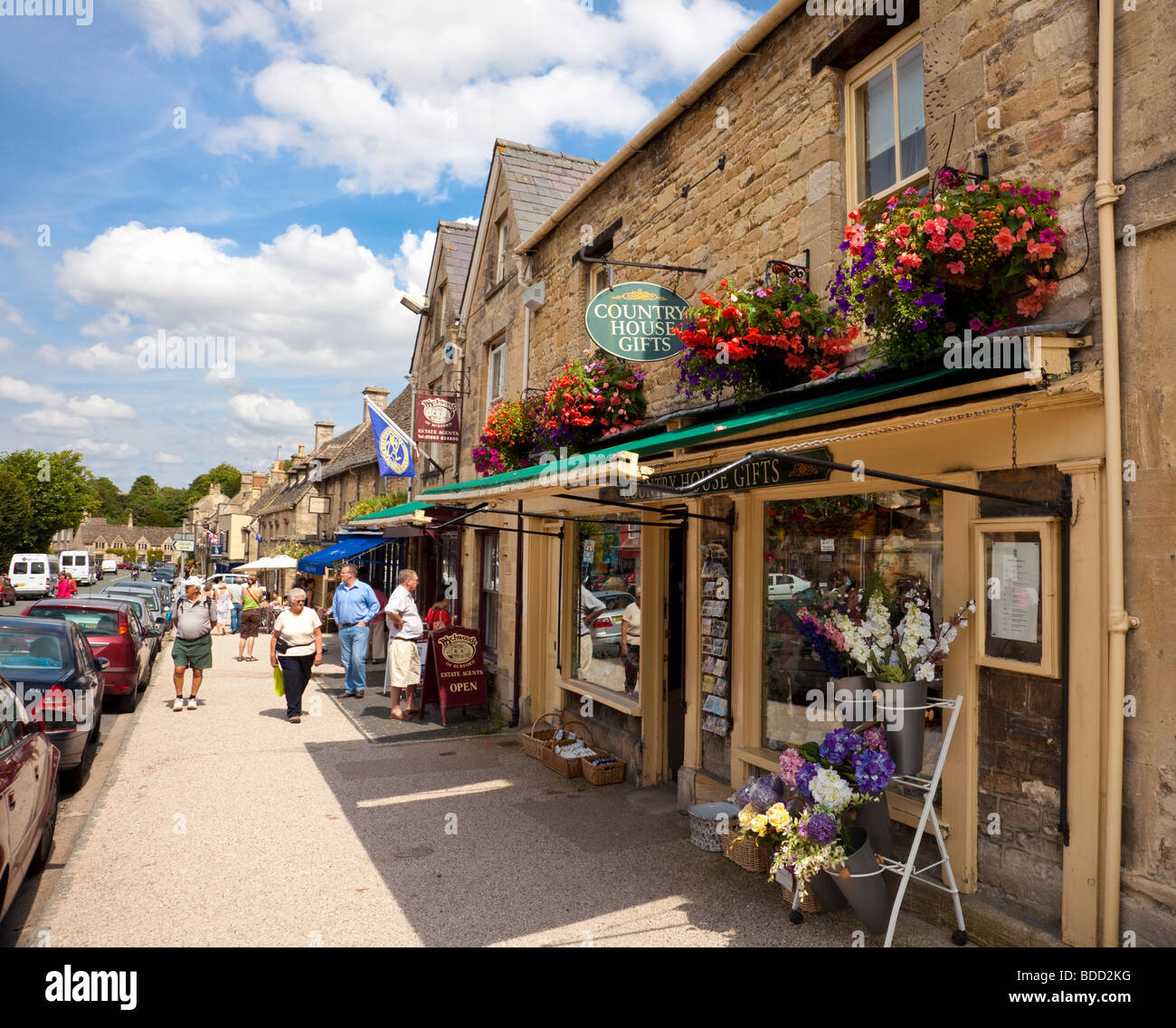 Alten Cotswolds Stadt von Burford, Oxfordshire, England, UK mit Läden und Geschäfte auf der High Street im Hochsommer Stockfoto