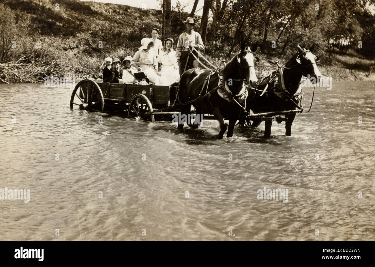 Familie in Pferd gezeichneten Wagen Fording River Stockfoto