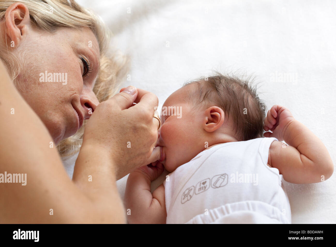 Neugeborenes Baby saugen am Finger Mütter Stockfoto