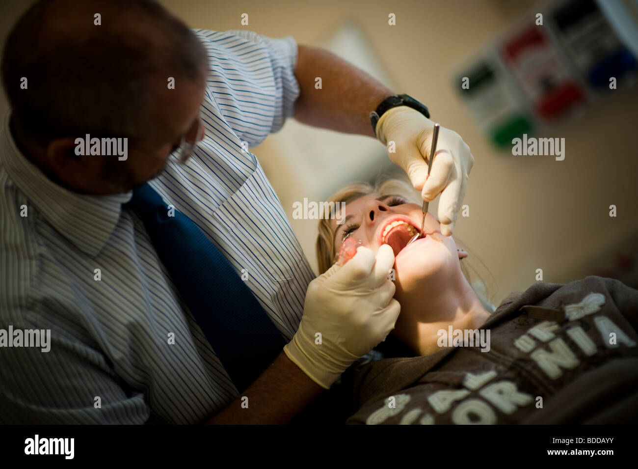 Teenager-Mädchen haben ihre zahnärztliche Klammer überprüft und korrigiert durch einen nationalen Gesundheitsdienst NHS Kieferorthopäden, Wales UK Stockfoto