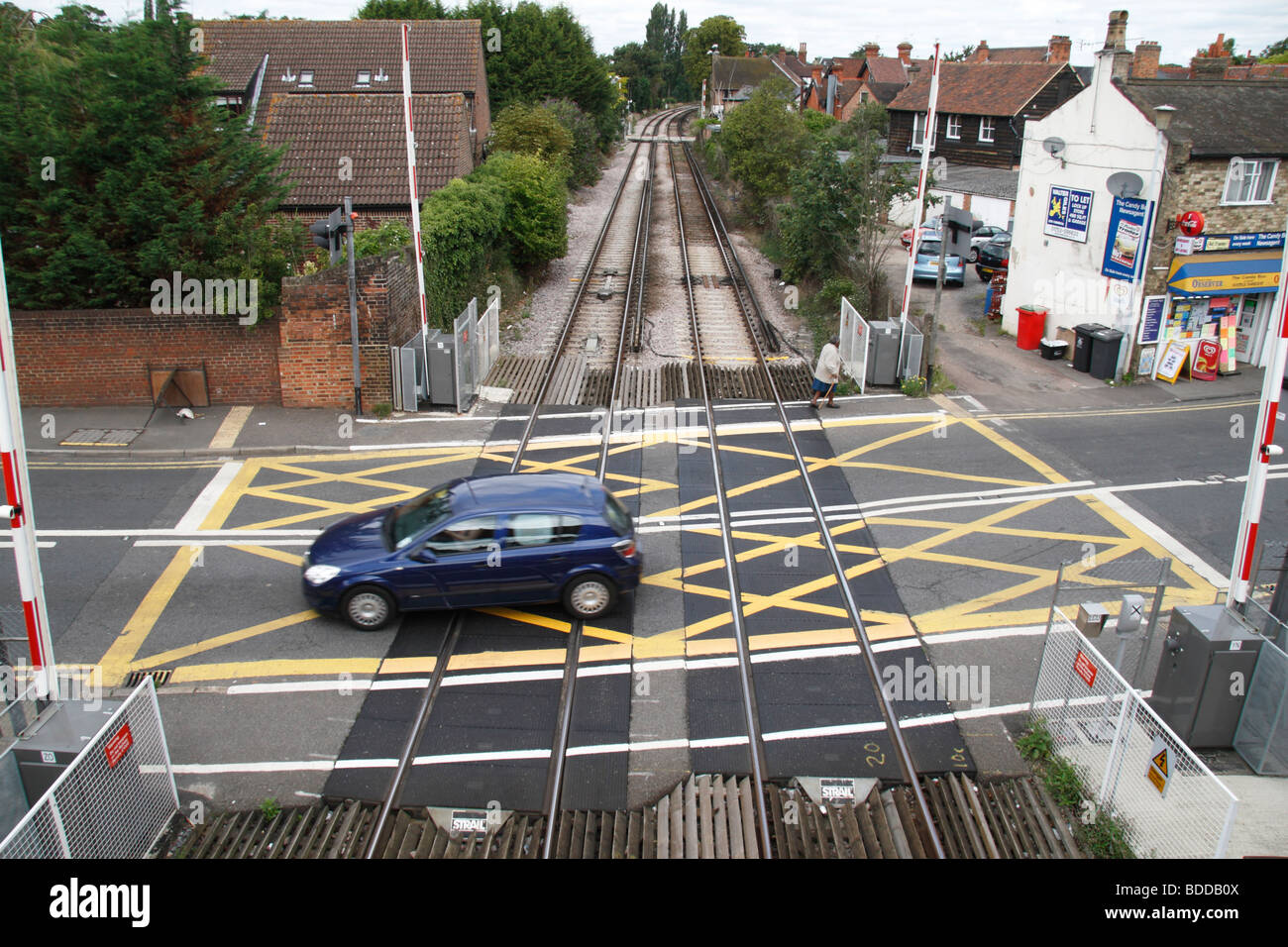 Ein Auto und ein Fußgänger auf einem Bahnübergang in Datchet, Berkshire, UK. Stockfoto