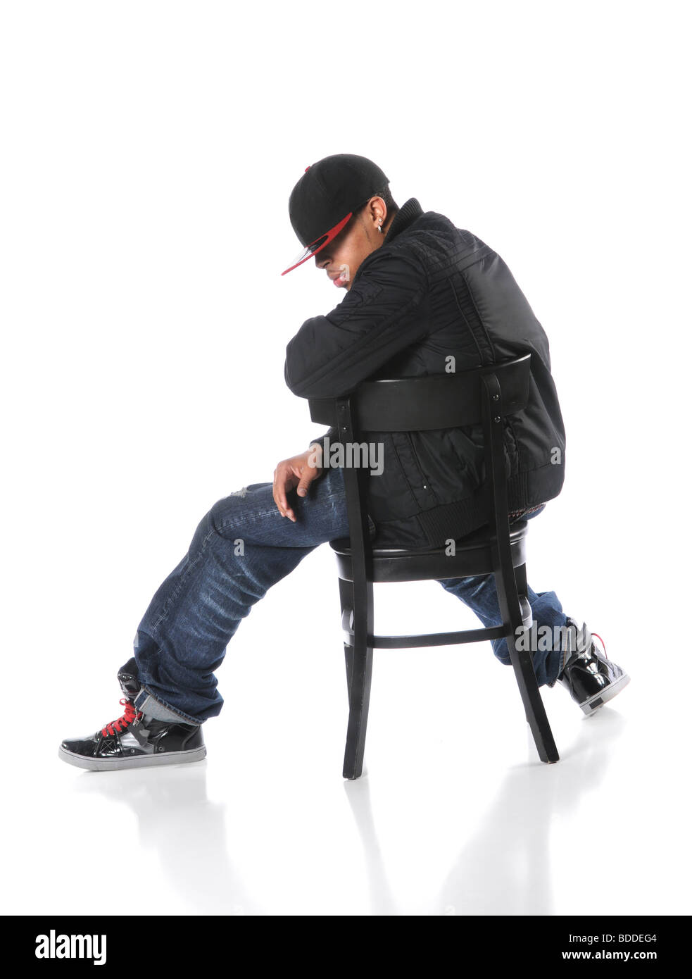 Afrikanische amerikanische Hip-Hop-Mann auf Stuhl sitzend auf einem weißen Hintergrund Stockfoto
