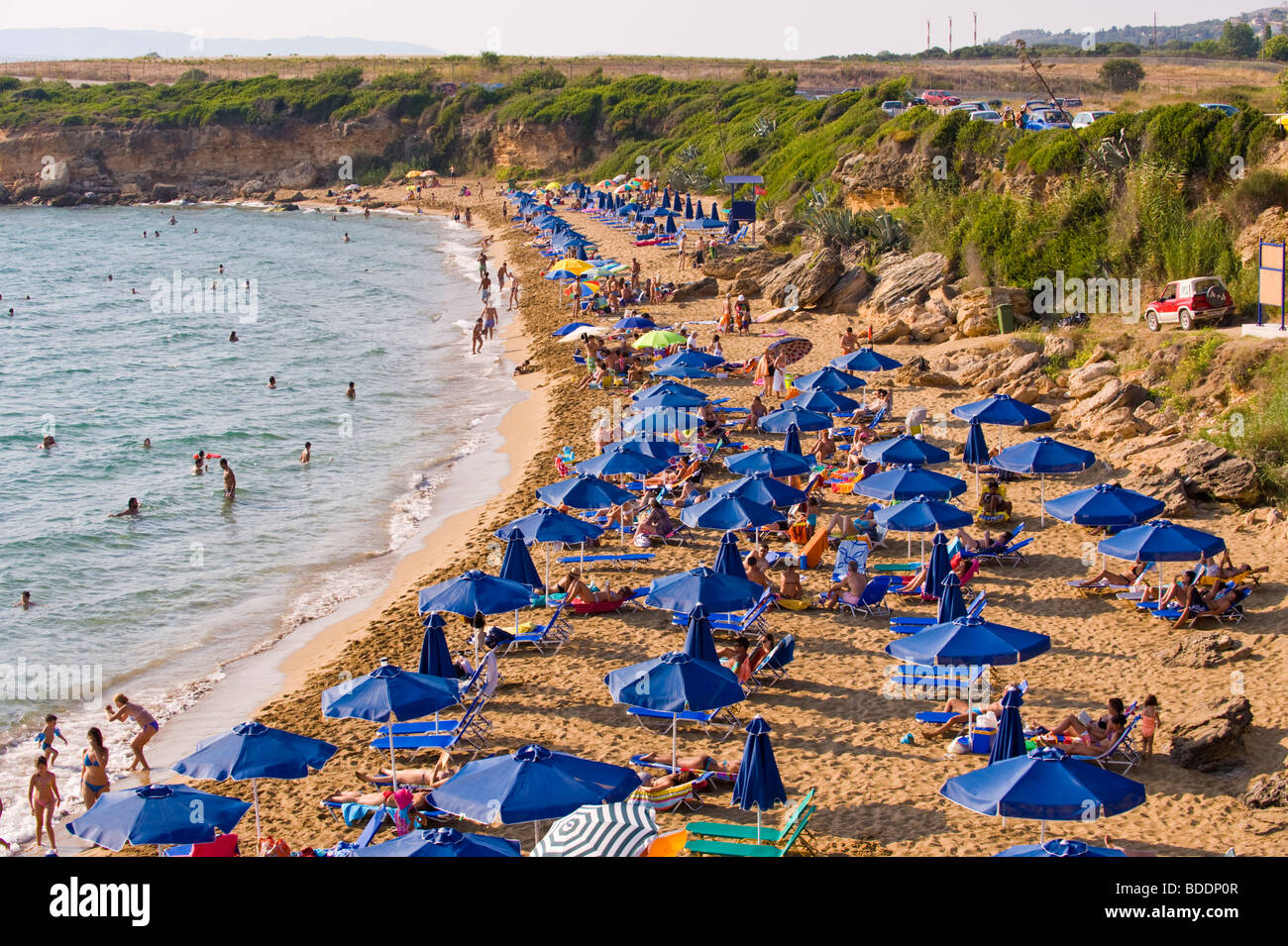 Urlauber, die Sonnenbaden auf einem überfüllten Ammes Beach auf der griechischen Mittelmeer Insel von Kefalonia Griechenland GR Stockfoto