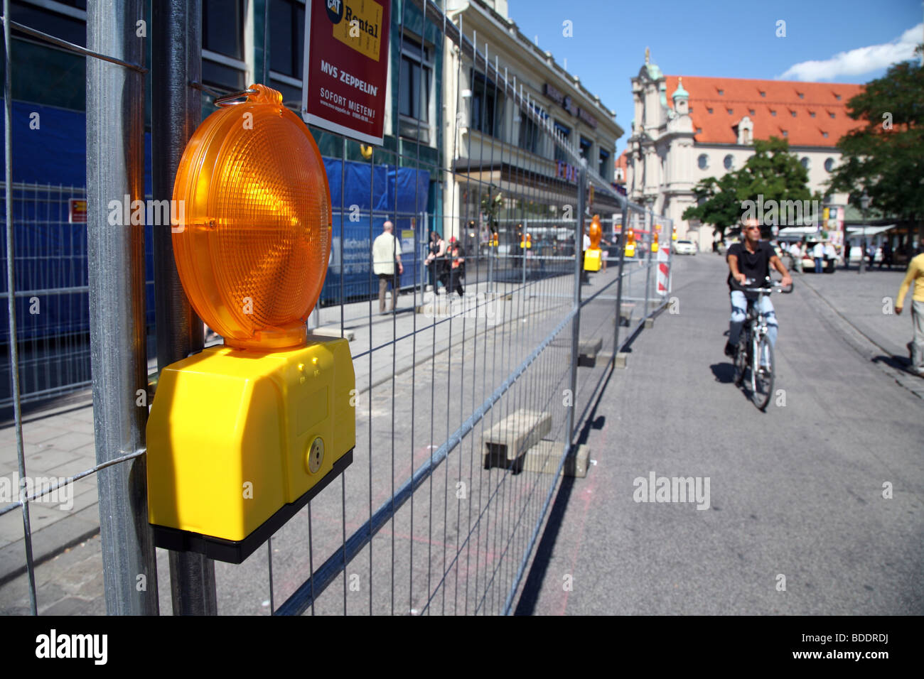 Radfahrer vorbei Straße Arbeit Zaun, zentrale München Stockfoto