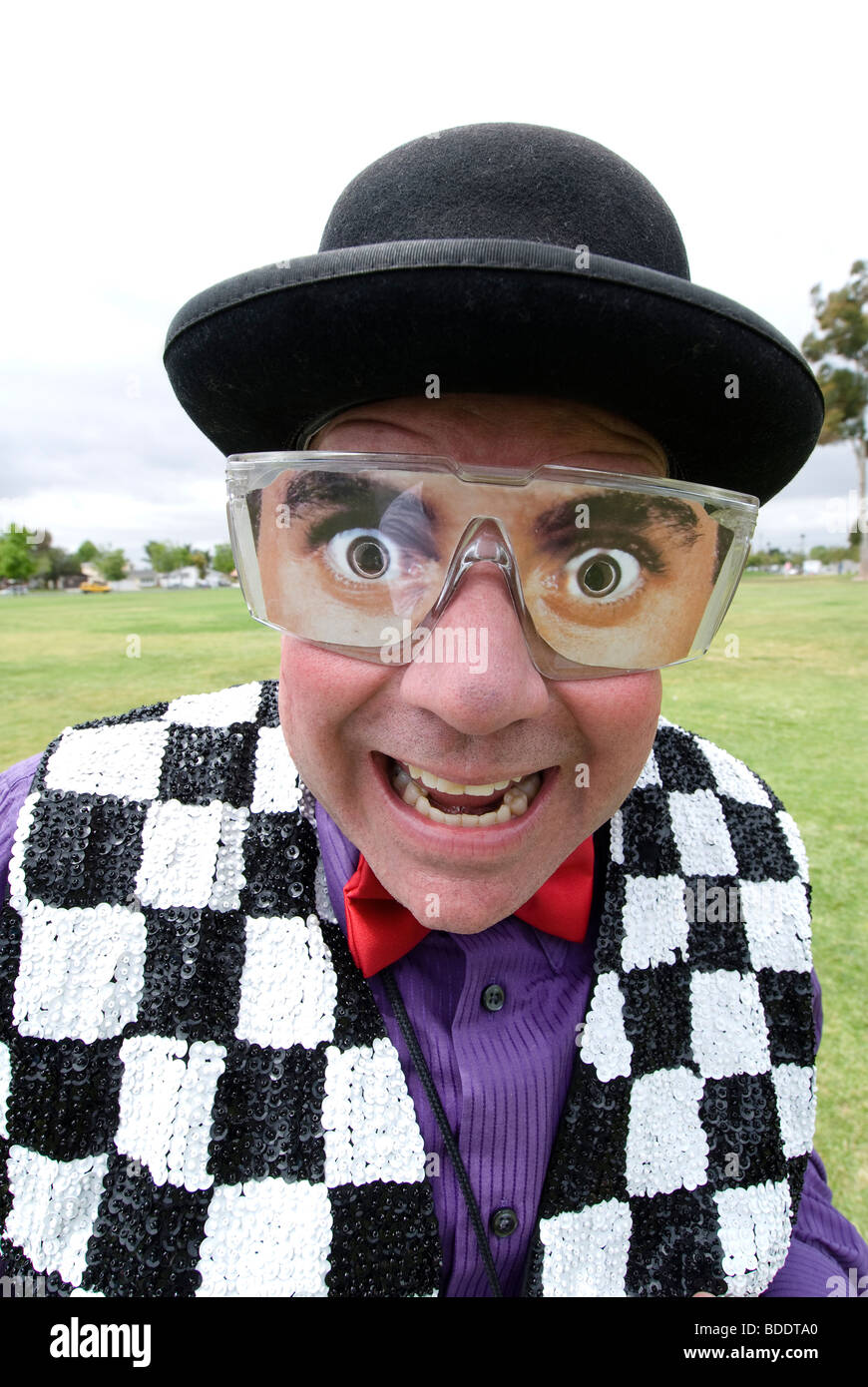 Ein Zauberer Entertainer mit gefälschten Brillen lächelt in die Kamera. Stockfoto