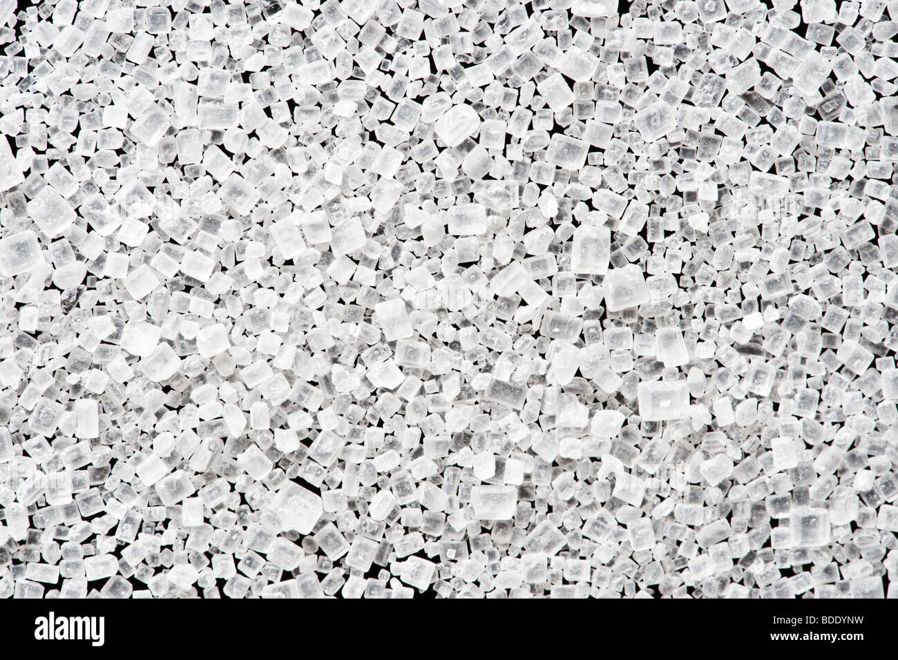 Granulierter Zuckerkristalle auf schwarzem Hintergrund Stockfoto