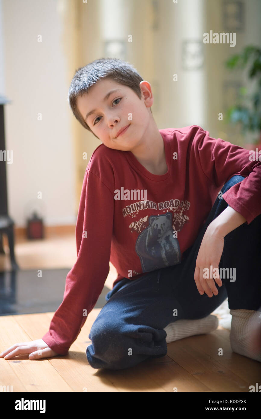 Porträt eines kleinen Jungen auf dem Boden sitzend Stockfoto