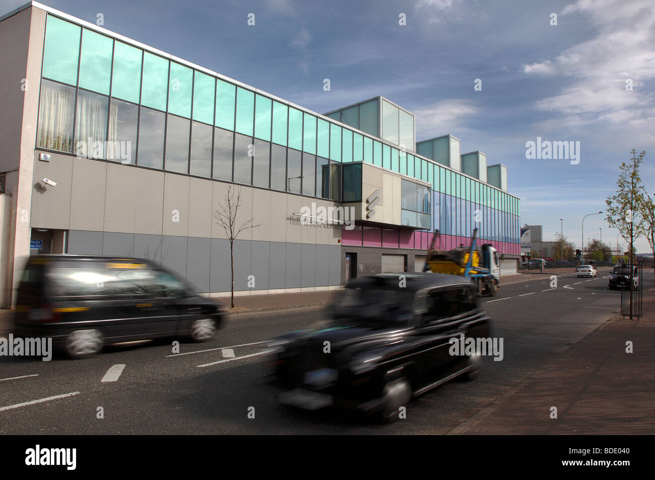 Irland, Norden, Belfast, West, Falls Road, außen an der renovierten fällt Schwimmbäder mit schwarzen Taxi Taxis vorbei. Stockfoto