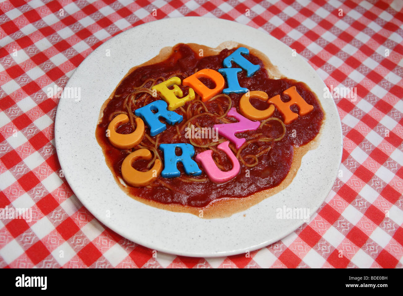 Kredit knirschte Spaghetti. Ein Teller Spaghetti in Tomatensauce mit einem "Kreditklemme"-Schild, Kunststoff Buchstaben. Stockfoto