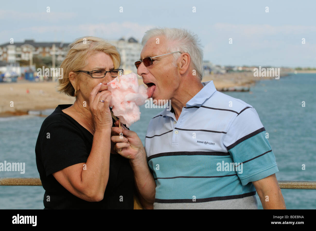 Mann und Frau essen Zuckerwatte am Meer Stockfoto