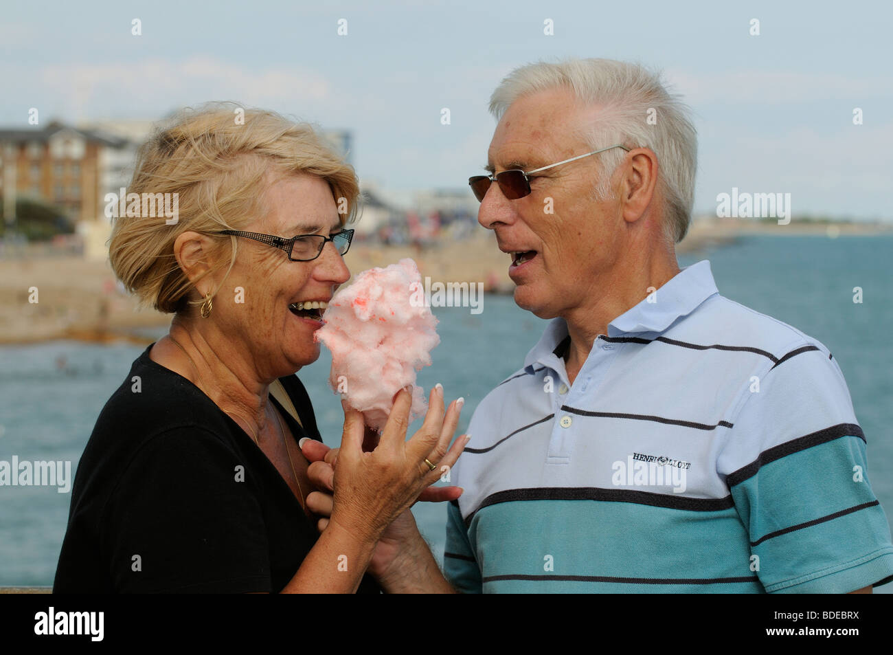 Mann und Frau essen Zuckerwatte am Meer Stockfoto