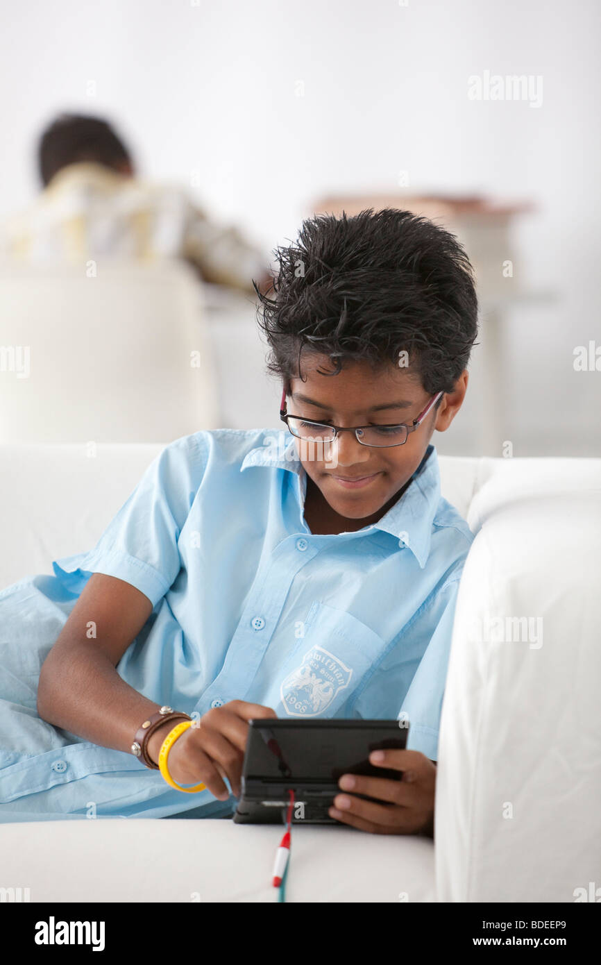 Teenager spielt auf ein game-boy Stockfoto