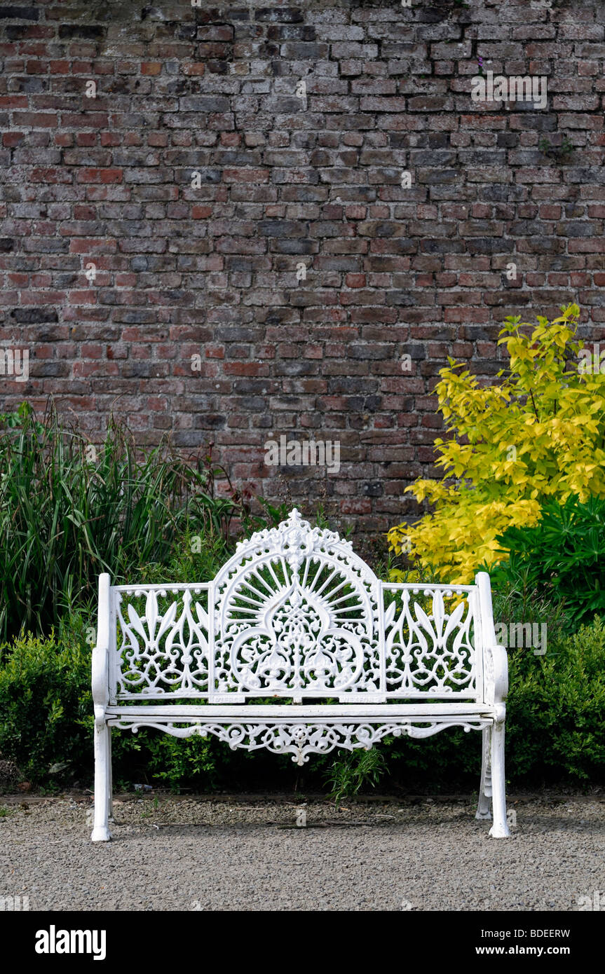 Schmiedeeisen Weißmetall Gartenbank formale vor Wand Stockfoto