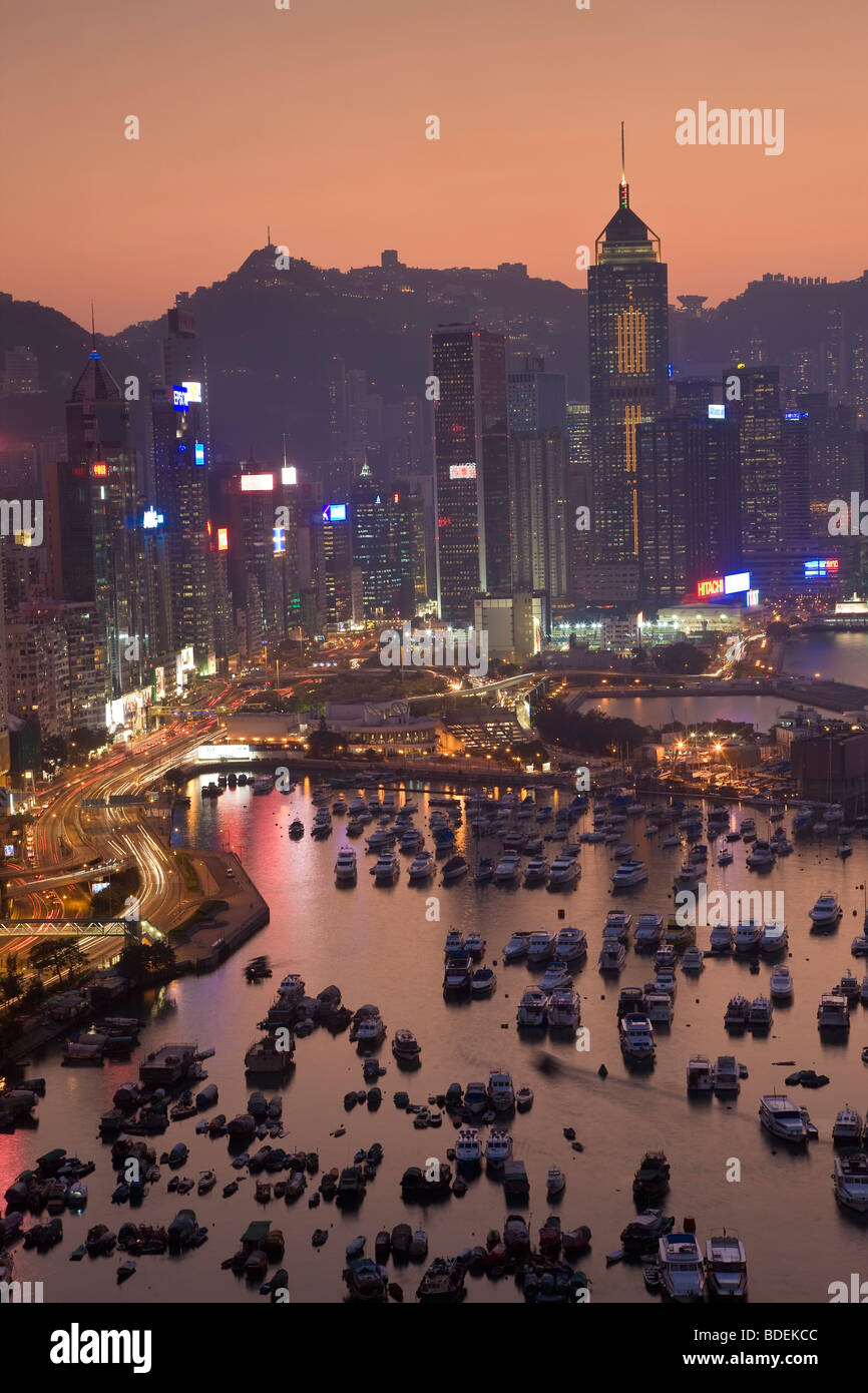 China, Hong Kong, Hong Kong Island, Blick über Hafen zum Victoria Peak bei Sonnenuntergang. Stockfoto