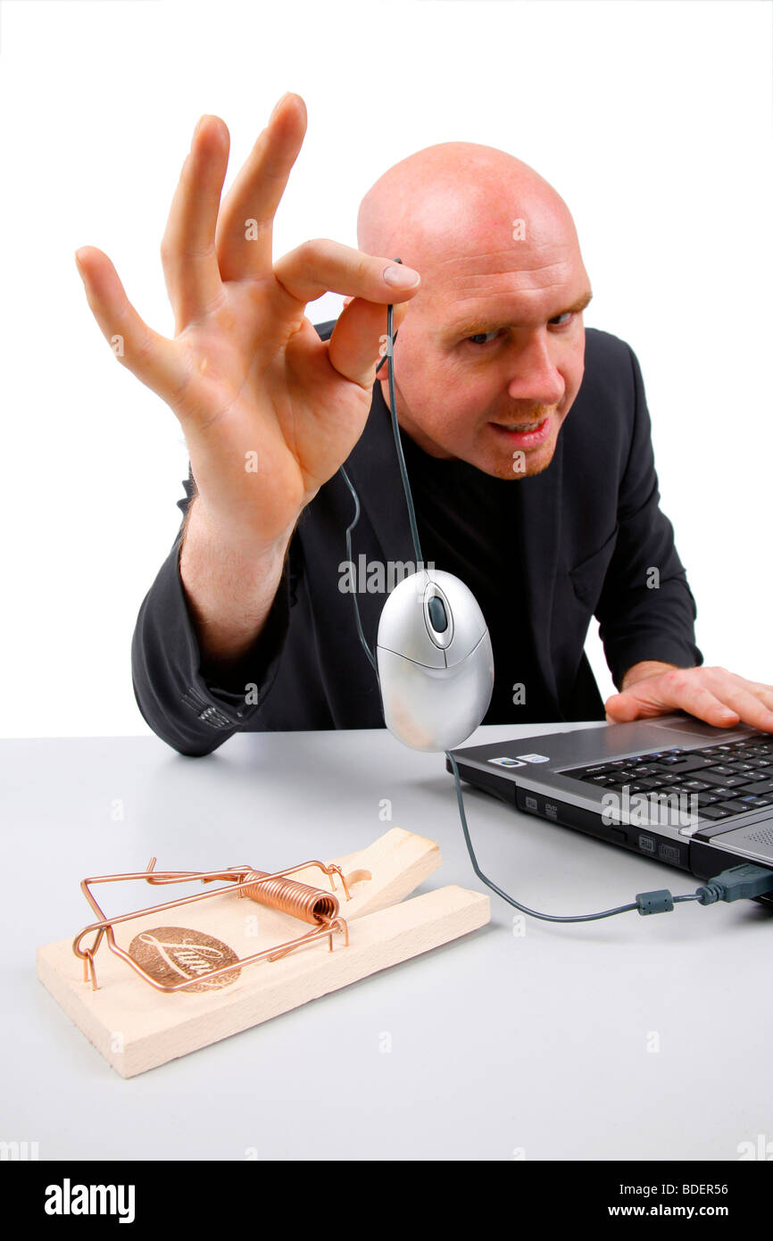 Leitung Glatzkopf hält eine Computer-Maus über Mausefalle Stockfoto