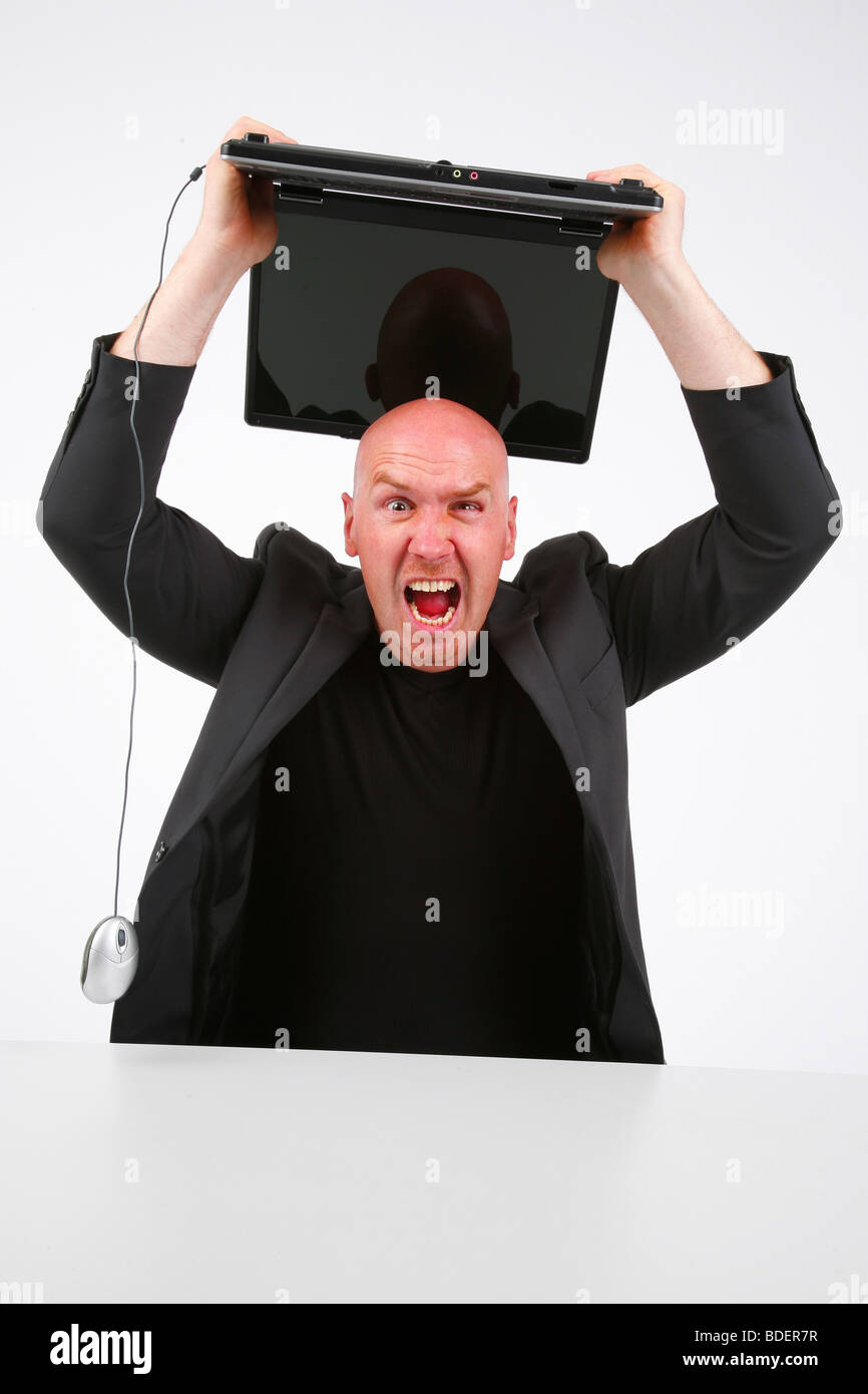 Leitung Glatzkopf mitzuhalten wütend einen Laptop über den Kopf Stockfoto