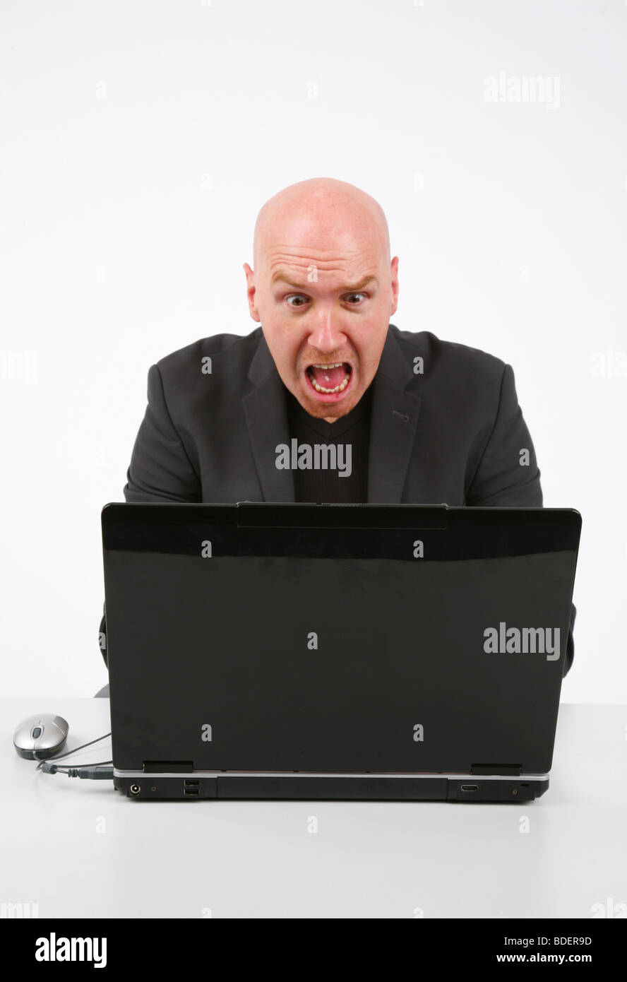 Glatze Mann sah entsetzt über seinen Laptop unter der Leitung Stockfoto