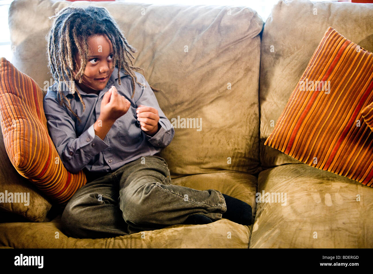 Porträt von Mischlinge Junge saß auf dem Sofa im Wohnzimmer Stockfoto