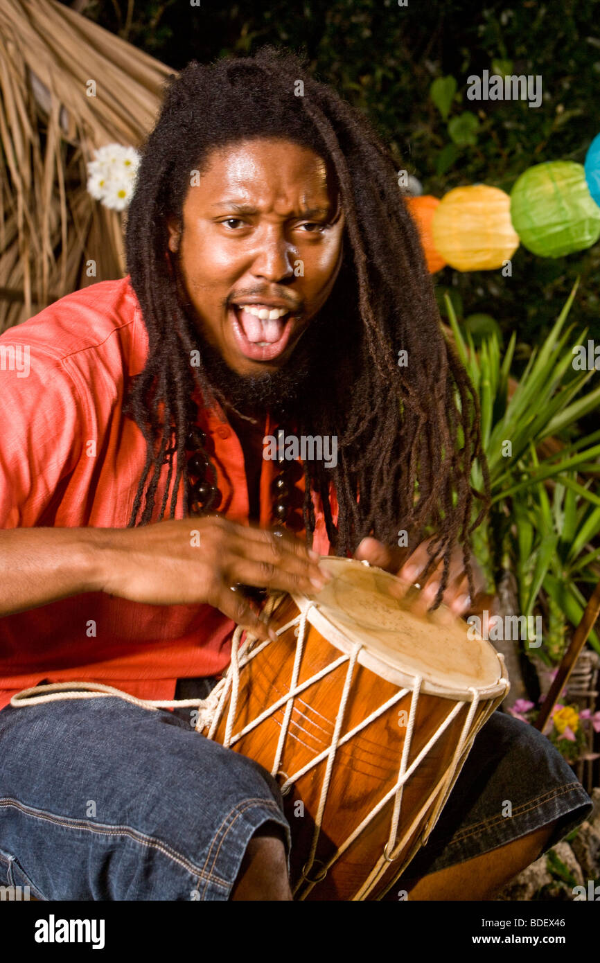 Jamaikanische Jüngling mit Dreadlocks spielt Bongo auf tropischen Insel Stockfoto