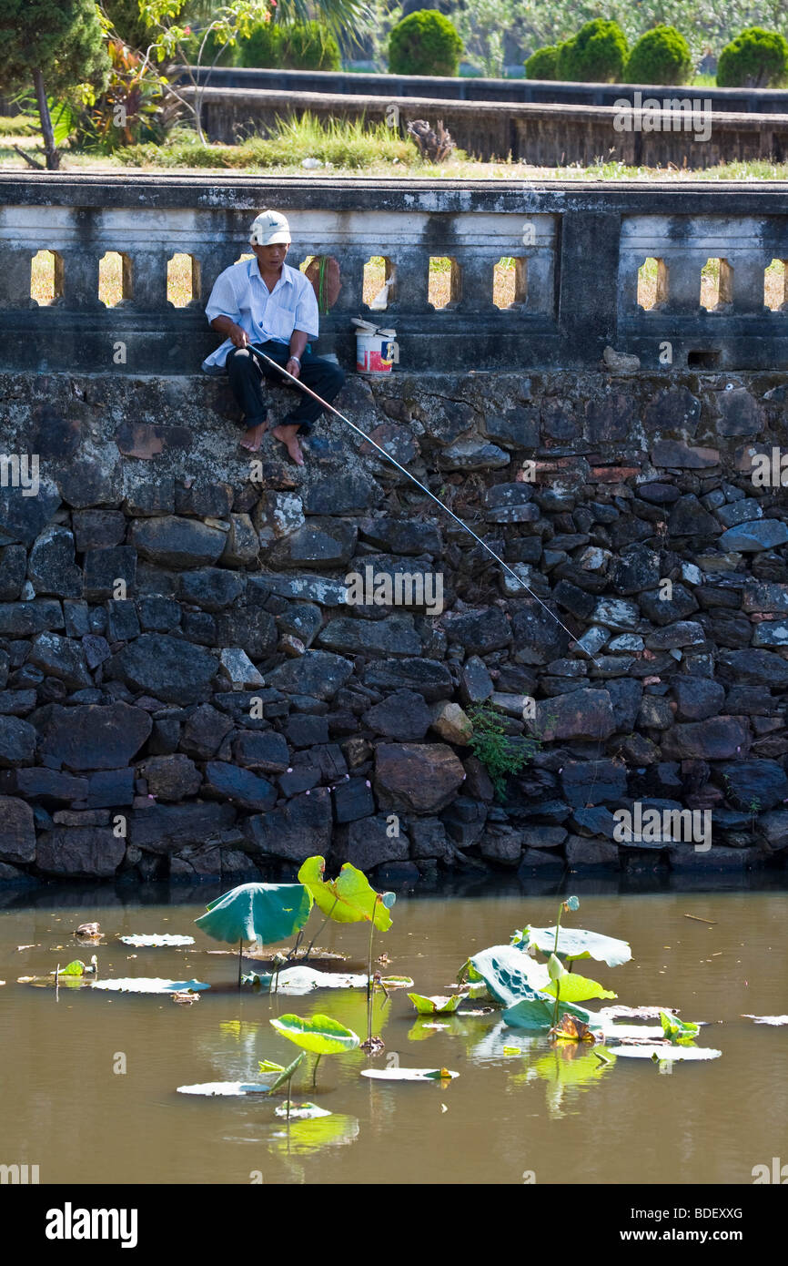 Ein einsamer Mann fischt im Graben rund um den Palast in Hue, Vietnam Stockfoto