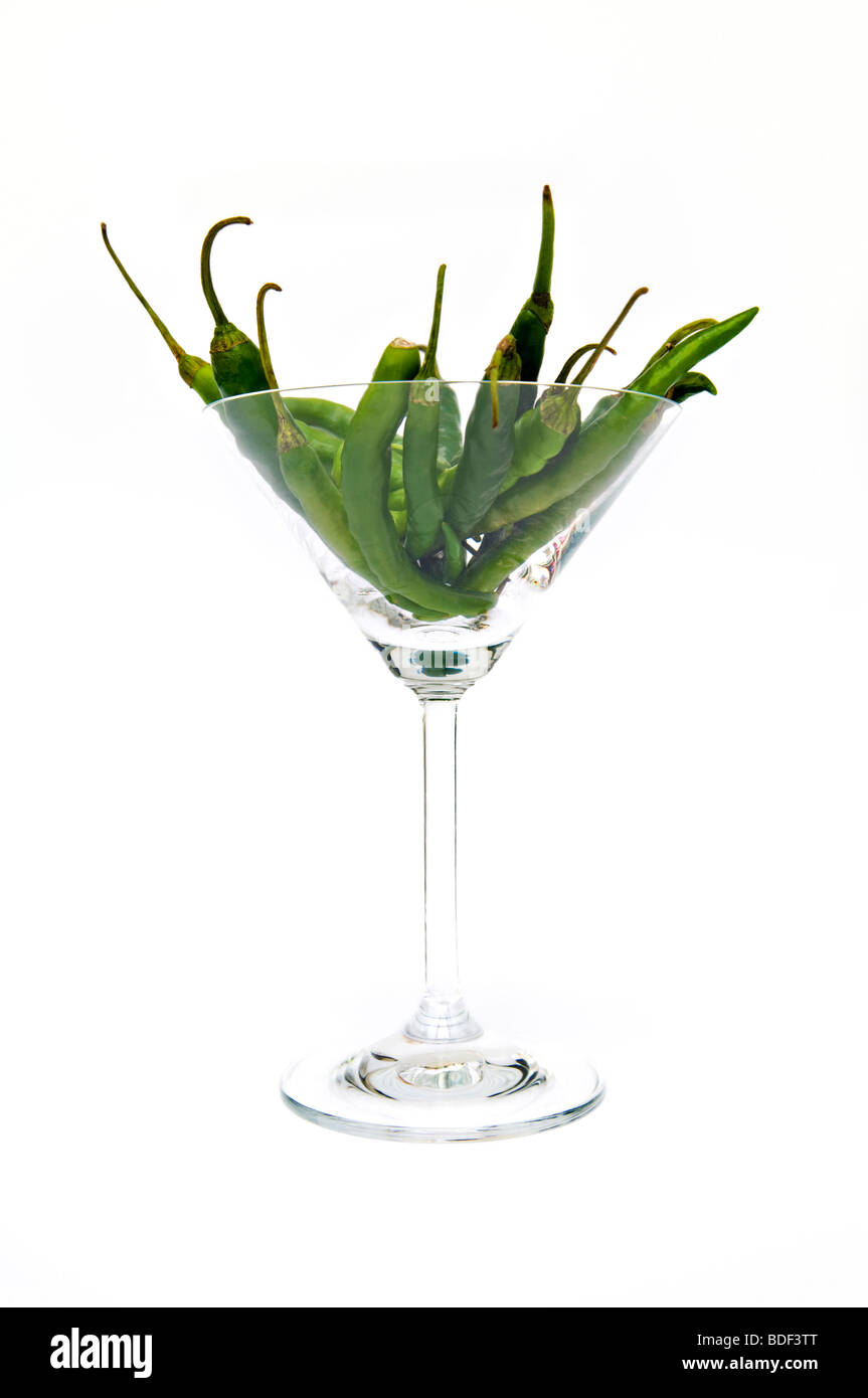 Studio Bild von grünen Chilischoten in Cocktailglas genommen vor einem weißen Hintergrund Stockfoto