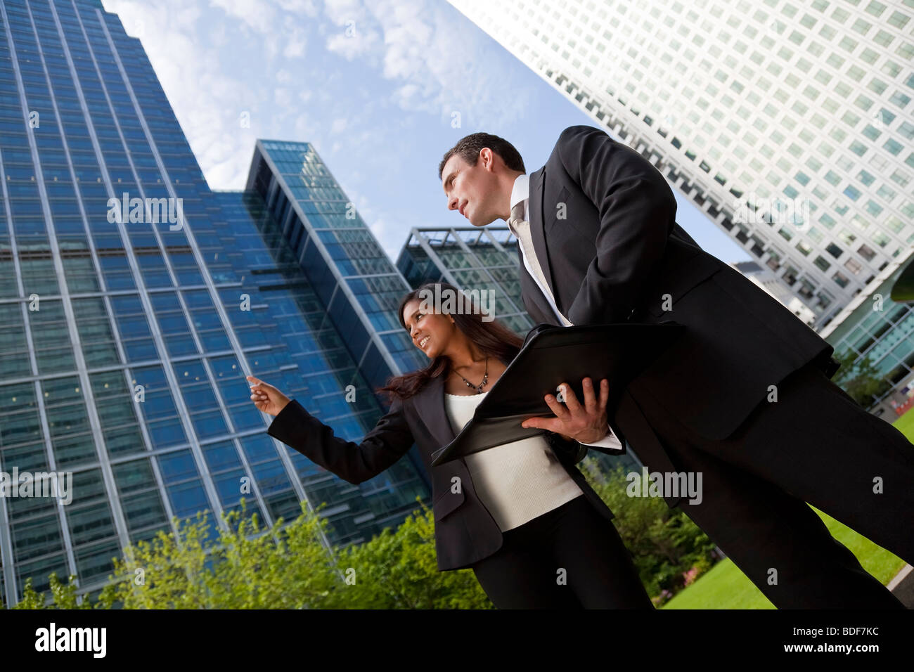 Eine lächelnde Geschäftsfrau und ihr männlicher Kollege Teilnahme an glücklich Geschäftstreffen außerhalb in einer modernen Stadt Stockfoto