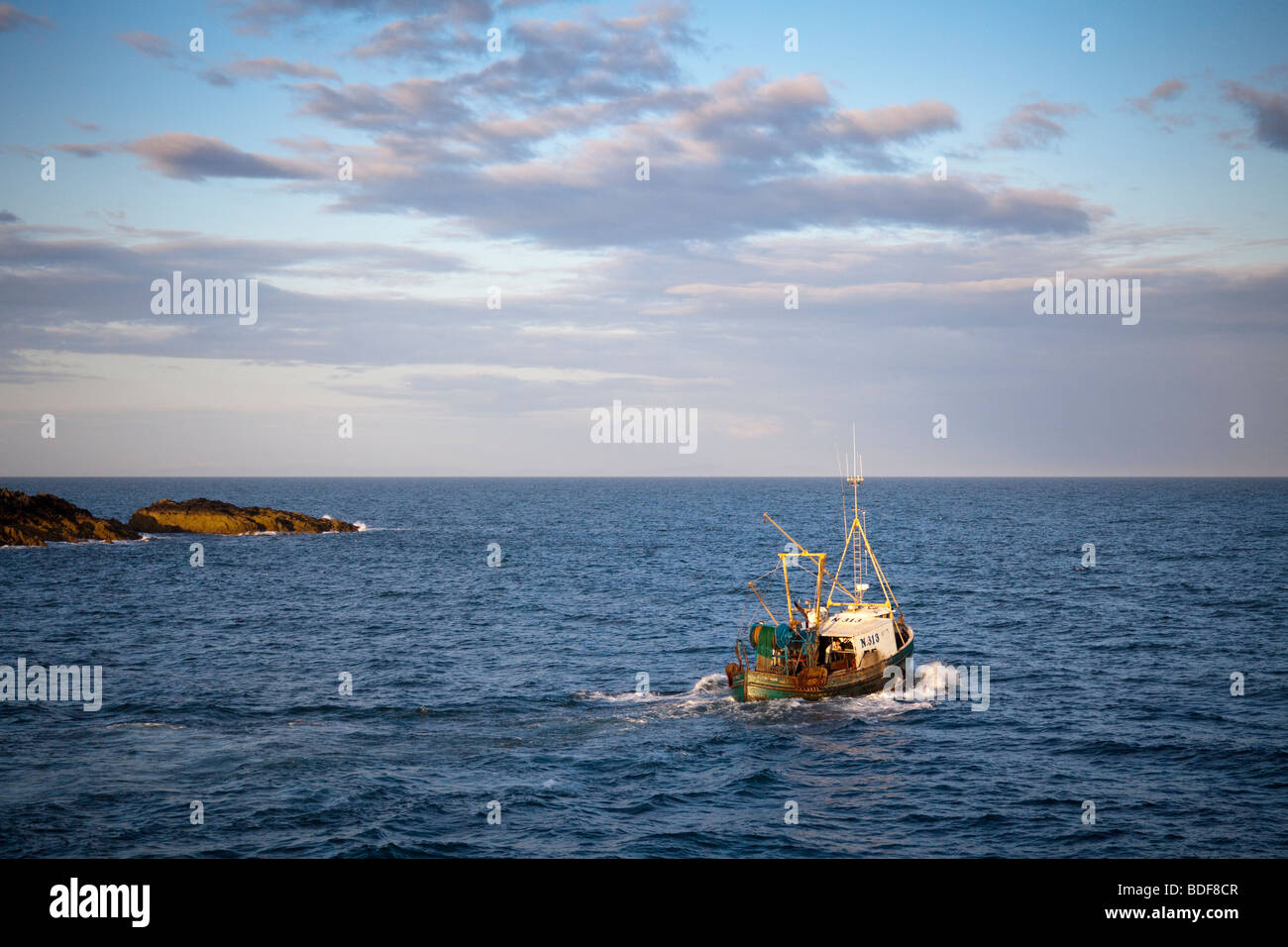 Fischtrawler Ardglass Hafen in der Abenddämmerung verlassen Stockfoto