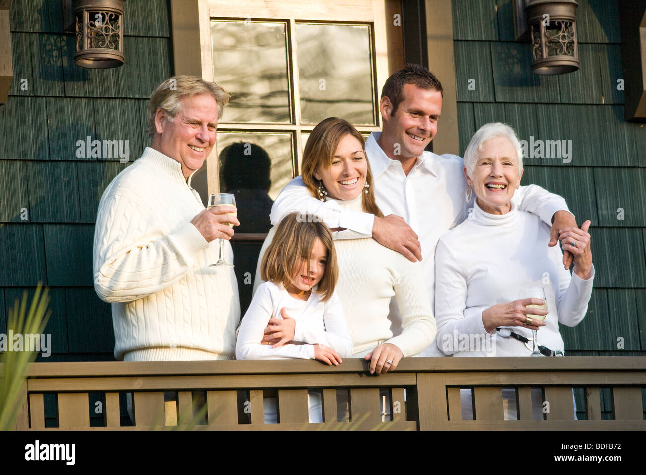 Multi-Generations Familie stehend auf der Veranda des Hauses mit Wein Stockfoto