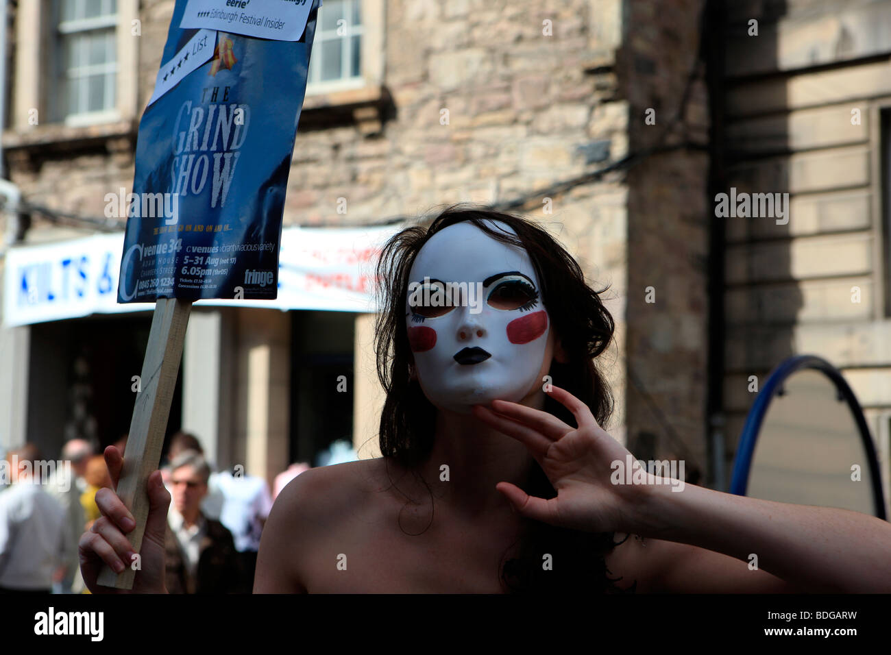 Mädchen mit einer weißen Maske auf fördert das Mahlen erscheinen auf dem Edinburgh Fringe Festival 2009 Stockfoto