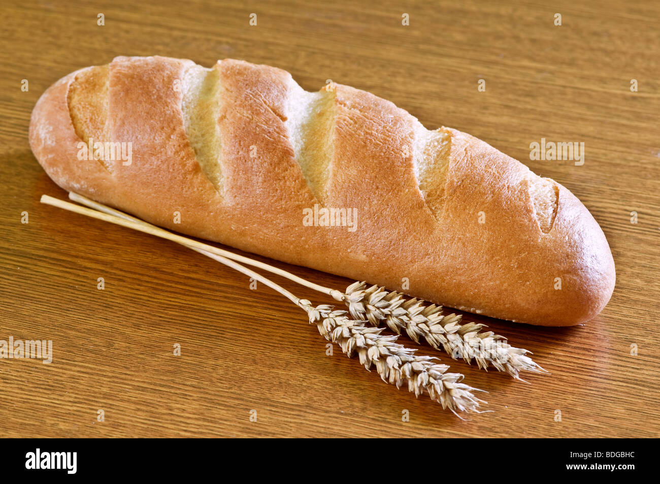 Brot und Weizen auf Holztisch Stockfoto