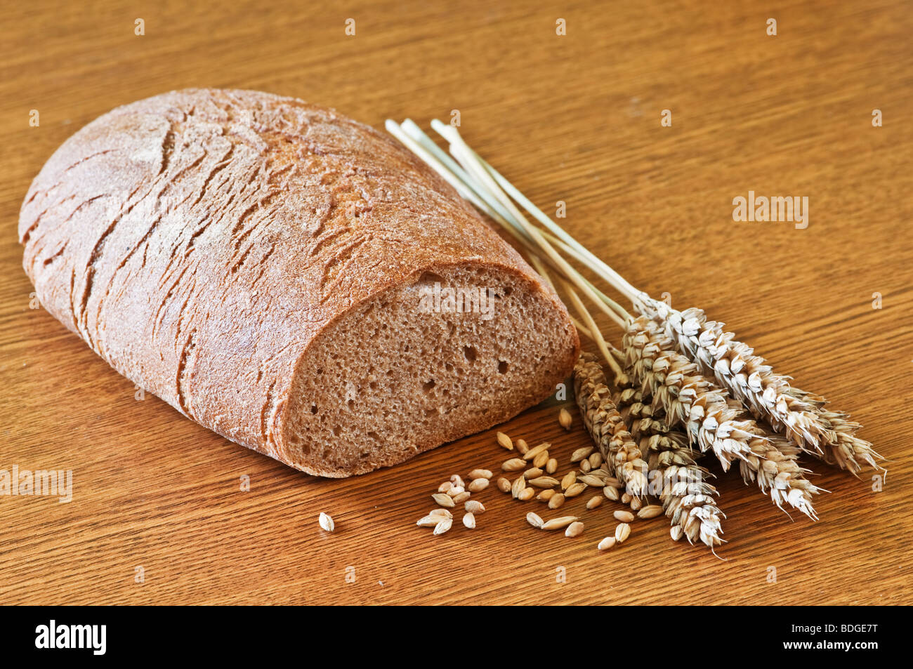 Brot mit Weizen auf Holztisch Stockfoto