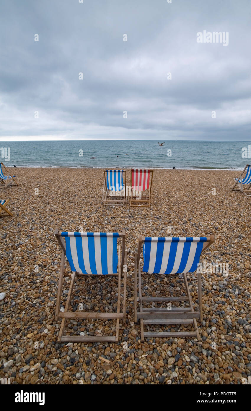 Brighton, Sussex, Großbritannien. Blau und weiß und rot und weiß gestreiften Liegestühlen für Holiday Maker Staycation, No u genießen Stockfoto
