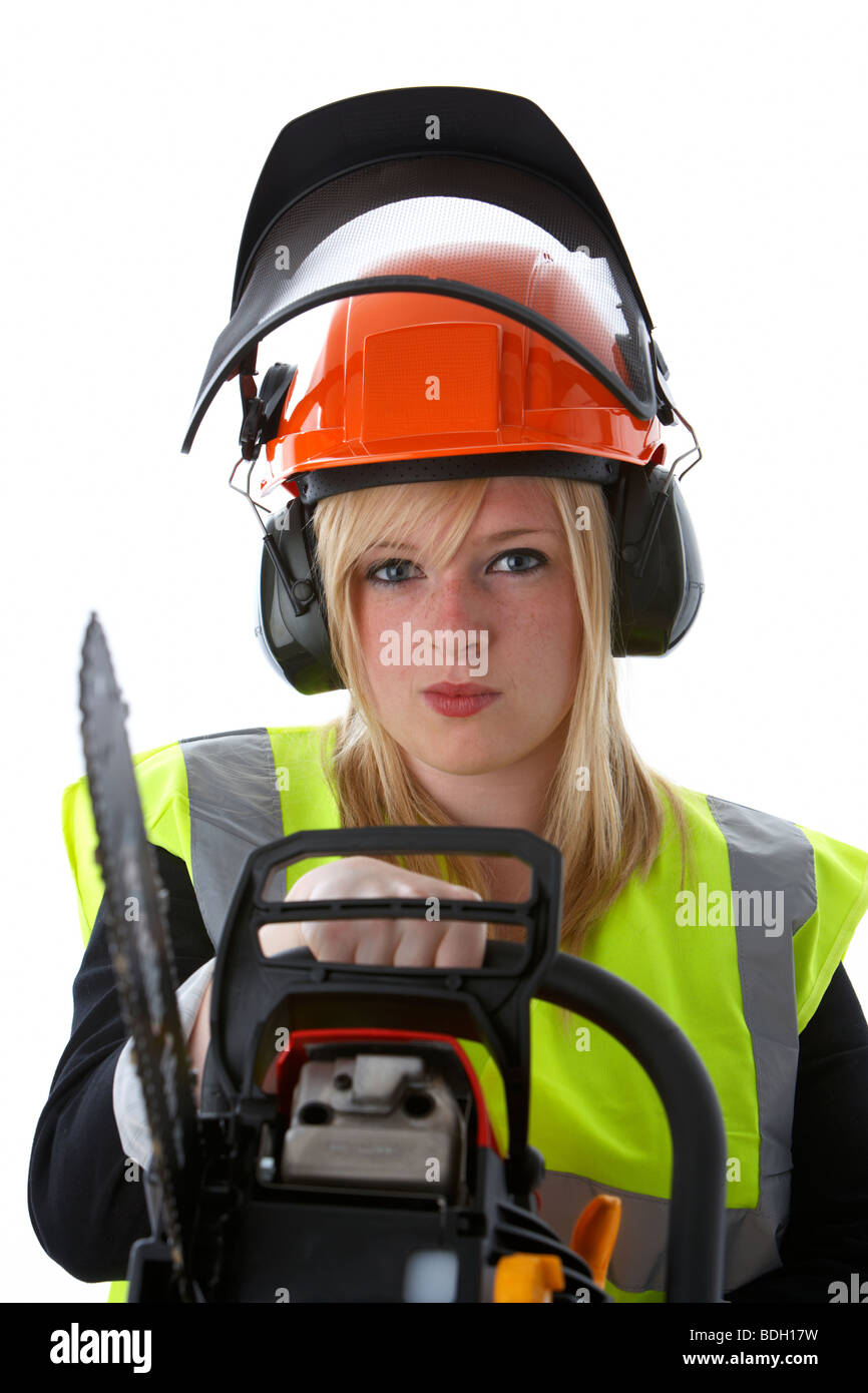 junge 20 jährige blonde Frau trägt orange Schutzhelm Ohr Protektoren Visier und hohe Vis-Weste mit Kettensäge suchen wütend Stockfoto
