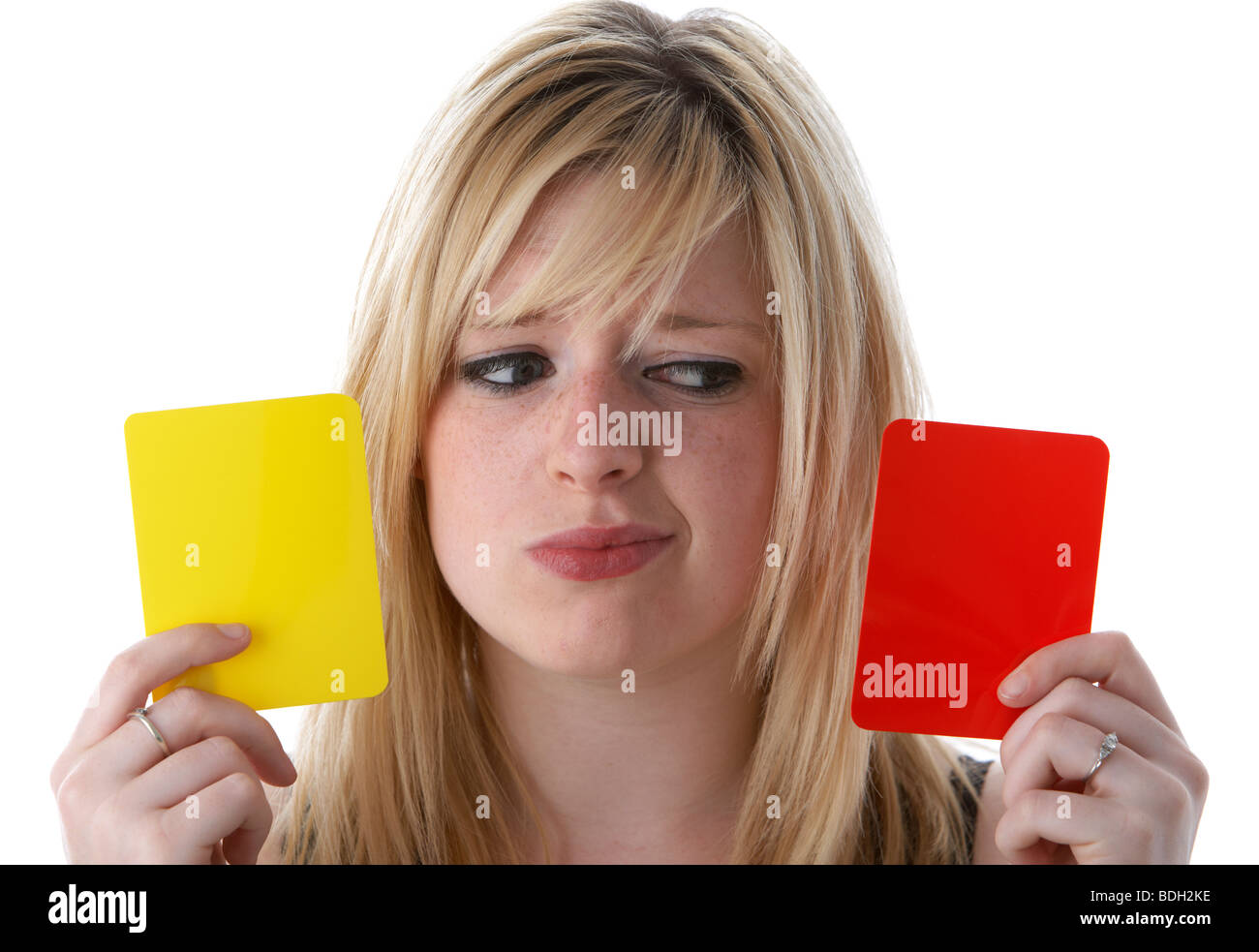 junge 20 jährige blonde Frau mit roten und gelben Fußball Fußball Warnung Karten mit verwirrten Blick auf ihrem Gesicht Stockfoto